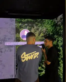 Visitors inside the GoQube room with forest imagery on the walls